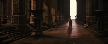 Movie still from “Thor: The Dark World” (2013), directed by Alan Taylor – A monk walking in the light of a large building; Extreme Wide shot, High angle