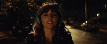 Movie still from “Timmy Failure: Mistakes Were Made” (2020), directed by Tom McCarthy – A woman with purple hair wearing blue headphones; Close Up shot, Overhead angle