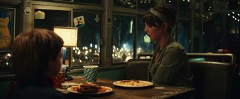 Movie still from “Timmy Failure: Mistakes Were Made” (2020), directed by Tom McCarthy – A woman sitting in front of a plate of food; Medium shot, Over the shoulder angle
