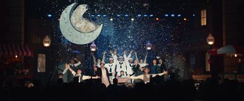 Movie still from “Timmy Failure: Mistakes Were Made” (2020), directed by Tom McCarthy – A group of people standing in front of a stage; Extreme Wide shot, High angle