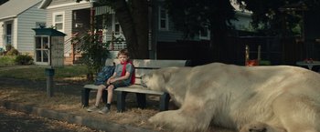Movie still from “Timmy Failure: Mistakes Were Made” (2020), directed by Tom McCarthy – A boy sitting on a park bench next to a large polar bear; Wide shot, Low angle
