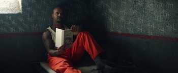 Movie still from “Timmy Failure: Mistakes Were Made” (2020), directed by Tom McCarthy – A man sitting on the floor reading a book; Medium shot, Overhead angle