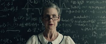 Movie still from “Timmy Failure: Mistakes Were Made” (2020), directed by Tom McCarthy – An older woman wearing glasses standing in front of a chalkboard; Close Up shot, Low angle