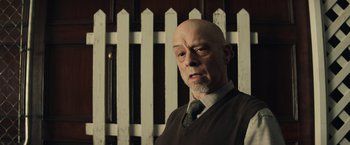 Movie still from “Timmy Failure: Mistakes Were Made” (2020), directed by Tom McCarthy – A bald man wearing a sweater and a tie; Close Up shot, Low angle