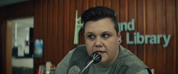 Movie still from “Timmy Failure: Mistakes Were Made” (2020), directed by Tom McCarthy – A person with a microphone in a room; Close Up shot, Over the shoulder angle