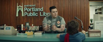 Movie still from “Timmy Failure: Mistakes Were Made” (2020), directed by Tom McCarthy – A person sitting at a table with a book; Medium shot, Over the shoulder angle