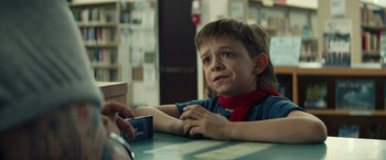 Movie still from “Timmy Failure: Mistakes Were Made” (2020), directed by Tom McCarthy – A young boy sitting at a table in a library; Close Up shot, Over the shoulder angle