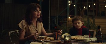 Movie still from “Timmy Failure: Mistakes Were Made” (2020), directed by Tom McCarthy – A woman sitting at a table with a plate of food; Medium shot, Over the shoulder angle