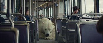 Movie still from “Timmy Failure: Mistakes Were Made” (2020), directed by Tom McCarthy – A polar bear laying down on a public transit bus; Wide shot, Low angle