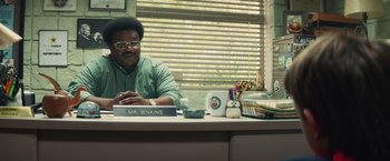 Movie still from “Timmy Failure: Mistakes Were Made” (2020), directed by Tom McCarthy – A man sitting at a desk in front of a window; Medium shot, Over the shoulder angle