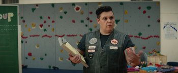 Movie still from “Timmy Failure: Mistakes Were Made” (2020), directed by Tom McCarthy – A person holding a wooden block in a room; Medium shot, Over the shoulder angle