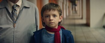 Movie still from “Timmy Failure: Mistakes Were Made” (2020), directed by Tom McCarthy – A young boy wearing a red scarf and a striped shirt; Close Up shot, Low angle
