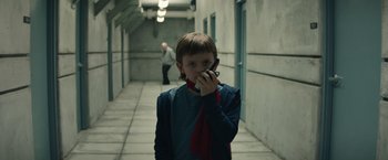 Movie still from “Timmy Failure: Mistakes Were Made” (2020), directed by Tom McCarthy – A young boy holding a cell phone up to his ear; Medium shot, Over the shoulder angle