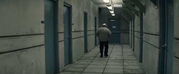 Movie still from “Timmy Failure: Mistakes Were Made” (2020), directed by Tom McCarthy – A man walking down a hallway in a building; Wide shot, High angle