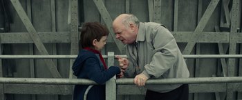 Movie still from “Timmy Failure: Mistakes Were Made” (2020), directed by Tom McCarthy – An older man and a young boy standing next to each other; Medium shot, Over the shoulder angle
