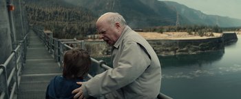 Movie still from “Timmy Failure: Mistakes Were Made” (2020), directed by Tom McCarthy – An older man and a young boy standing next to a body of water; Medium shot, Over the shoulder angle