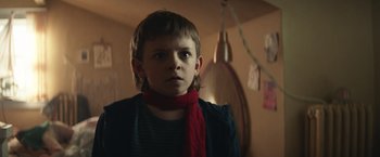 Movie still from “Timmy Failure: Mistakes Were Made” (2020), directed by Tom McCarthy – A young boy wearing a red scarf in a dark room; Close Up shot, Low angle