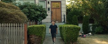 Movie still from “Timmy Failure: Mistakes Were Made” (2020), directed by Tom McCarthy – A young boy walking down the steps of a house; Wide shot, Low angle