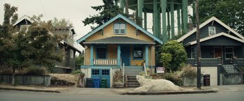 Movie still from “Timmy Failure: Mistakes Were Made” (2020), directed by Tom McCarthy – A white bear laying in front of a yellow house; Extreme Wide shot, Low angle