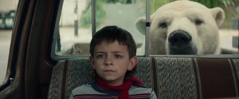 Movie still from “Timmy Failure: Mistakes Were Made” (2020), directed by Tom McCarthy – A boy sitting in front of a window with a polar bear behind him; Close Up shot, Low angle