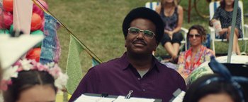Movie still from “Timmy Failure: Mistakes Were Made” (2020), directed by Tom McCarthy – A man sitting in the grass wearing a purple shirt; Close Up shot, Low angle
