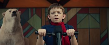 Movie still from “Timmy Failure: Mistakes Were Made” (2020), directed by Tom McCarthy – A young boy wearing a red scarf while sitting on a bike; Close Up shot, Low angle