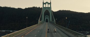 Movie still from “Timmy Failure: Mistakes Were Made” (2020), directed by Tom McCarthy – A person riding a skateboard across a bridge; Extreme Wide shot, High angle