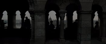 Movie still from “Tinker Tailor Soldier Spy” (2011), directed by Tomas Alfredson – A view of a city from a building with arches and columns; Extreme Wide shot, Low angle