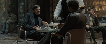 Movie still from “Tinker Tailor Soldier Spy” (2011), directed by Tomas Alfredson – A man sitting at a table with a tray of food in front of him; Medium shot, Over the shoulder angle