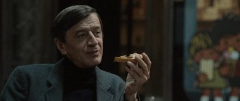 Movie still from “Tinker Tailor Soldier Spy” (2011), directed by Tomas Alfredson – A person holding a piece of bread; Close Up shot, Over the shoulder angle