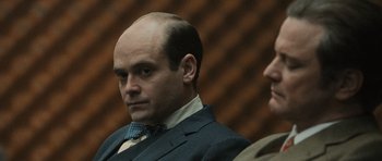 Movie still from “Tinker Tailor Soldier Spy” (2011), directed by Tomas Alfredson – A man in a suit and tie next to another man in a suit and tie; Close Up shot, Over the shoulder angle