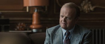 Movie still from “Tinker Tailor Soldier Spy” (2011), directed by Tomas Alfredson – An older man wearing a suit and tie; Close Up shot, Over the shoulder angle