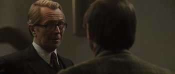 Movie still from “Tinker Tailor Soldier Spy” (2011), directed by Tomas Alfredson – A man in a suit looking at himself in the mirror; Close Up shot, Over the shoulder angle