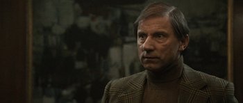 Movie still from “Tinker Tailor Soldier Spy” (2011), directed by Tomas Alfredson – An older man wearing a sweater and a plaid jacket; Close Up shot, Low angle