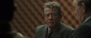 Movie still from “Tinker Tailor Soldier Spy” (2011), directed by Tomas Alfredson – An older man wearing a suit and tie; Close Up shot, Over the shoulder angle