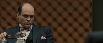 Movie still from “Tinker Tailor Soldier Spy” (2011), directed by Tomas Alfredson – A bald man in a suit and tie; Close Up shot, Over the shoulder angle