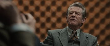 Movie still from “Tinker Tailor Soldier Spy” (2011), directed by Tomas Alfredson – An older man wearing a suit and tie; Close Up shot, Over the shoulder angle