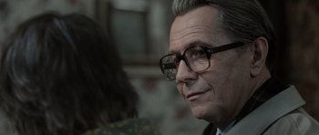Movie still from “Tinker Tailor Soldier Spy” (2011), directed by Tomas Alfredson – An older man wearing glasses looking at the camera; Close Up shot, Over the shoulder angle