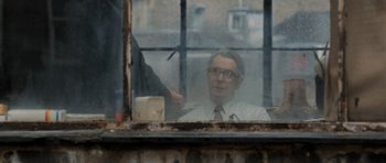 Movie still from “Tinker Tailor Soldier Spy” (2011), directed by Tomas Alfredson – An old man looking out of a broken window; Close Up shot, Over the shoulder angle