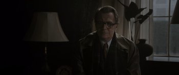 Movie still from “Tinker Tailor Soldier Spy” (2011), directed by Tomas Alfredson – An older man wearing glasses and a coat; Close Up shot, Over the shoulder angle