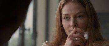 Movie still from “Tinker Tailor Soldier Spy” (2011), directed by Tomas Alfredson – A person holding a cigarette in her mouth; Close Up shot, Over the shoulder angle