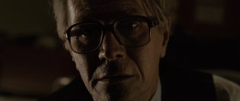 Movie still from “Tinker Tailor Soldier Spy” (2011), directed by Tomas Alfredson – An older man wearing glasses looking at the camera; Close Up shot, Low angle