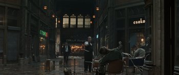 Movie still from “Tinker Tailor Soldier Spy” (2011), directed by Tomas Alfredson – A man sitting at a table in the rain; Wide shot, Over the shoulder angle