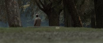 Movie still from “Tinker Tailor Soldier Spy” (2011), directed by Tomas Alfredson – An older man sitting in front of some trees; Extreme Wide shot, Over the shoulder angle