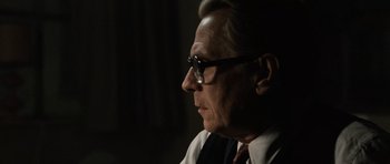 Movie still from “Tinker Tailor Soldier Spy” (2011), directed by Tomas Alfredson – An older man wearing glasses and a tie; Close Up shot, Over the shoulder angle