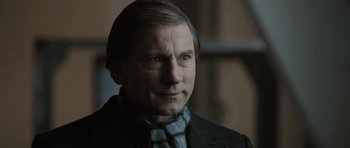 Movie still from “Tinker Tailor Soldier Spy” (2011), directed by Tomas Alfredson – A person wearing a suit and tie; Close Up shot, Over the shoulder angle