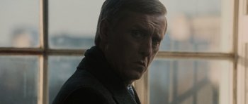 Movie still from “Tinker Tailor Soldier Spy” (2011), directed by Tomas Alfredson – A person wearing a suit and tie; Close Up shot, Over the shoulder angle