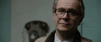 Movie still from “Tinker Tailor Soldier Spy” (2011), directed by Tomas Alfredson – An older man wearing glasses and a tie; Close Up shot, Low angle