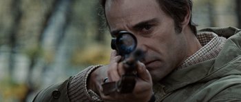 Movie still from “Tinker Tailor Soldier Spy” (2011), directed by Tomas Alfredson – A person holding a gun; Close Up shot, Over the shoulder angle