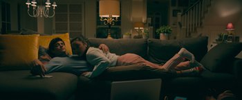 Movie still from “To All the Boys: Always and Forever” (2021), directed by Michael Fimognari – A person laying on a couch in a living room; Medium shot, High angle